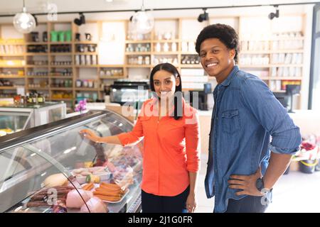 Portrait of smiling young multiracial couple shopping together in coffee shop. unaltered, cafe culture, people, love and lifestyle concept. Stock Photo