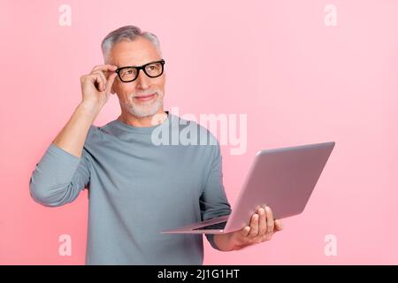 Photo of smart thoughtful retired man wear grey shirt spectacles writing modern gadget empty space isolated pink color background Stock Photo