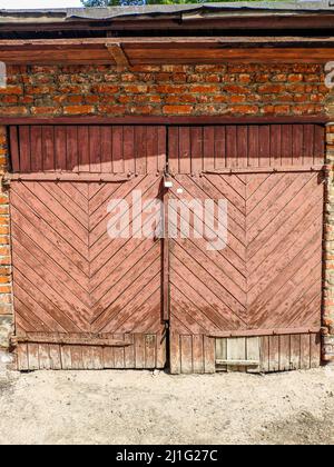 Pink wooden door to an old garage. Stock Photo