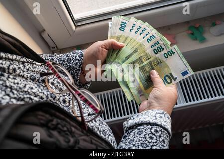 Close up on hands of unknown caucasian senior woman holding and counting 100 euro banknotes money wealth insurance payment or lifetime savings copy sp Stock Photo