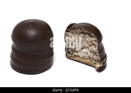 Close up of chocolate coated marshmallow fitted on cookie filled with sugar foam and covered with chocolate next to one cut in half showing the inside Stock Photo