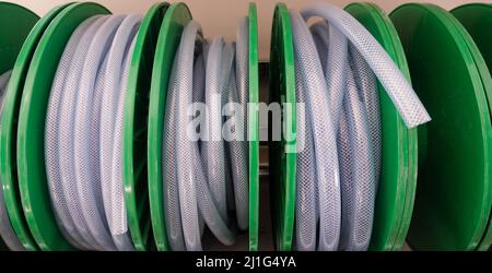New Long White Plastic Water Hose in Roll. Stock Photo