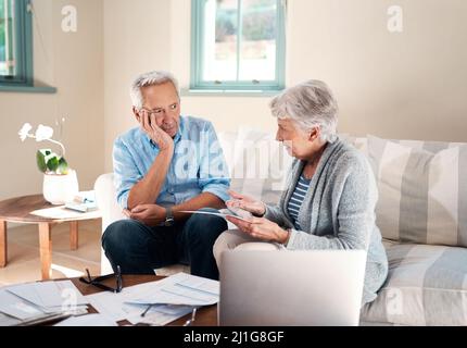 Nothing puts strain on a marriage like financial stress. Shot of a senior couple having a disagreement while going through paperwork at home. Stock Photo