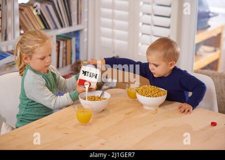 Hes so helpful. Shot of a young brother and sister making breakfast at home. Stock Photo