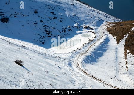 snowy mountain landscape with small frozen lake Stock Photo