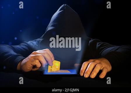 Cyber thief stealing a credit card from a cell phone. Phishing alert. Bank data theft Stock Photo