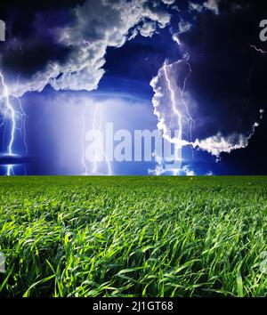 Thunderstorm with lightning in green meadow. Dark ominous clouds. Stock Photo