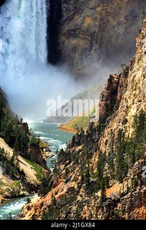 Base of Yellowstone's famous Lower Falls is covered in a rush of water and flying mist.  Canyon walls are steep and rugged. Stock Photo