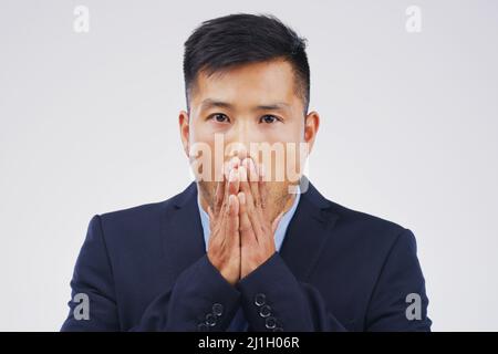 I messed up big time. Studio shot of a young man looking shocked against a grey background. Stock Photo