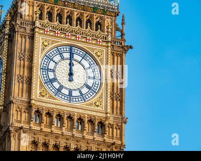 Big Ben at midday. Close detail of the face to the iconic London landmark clock tower at exactly 12 o'clock mid day. Stock Photo
