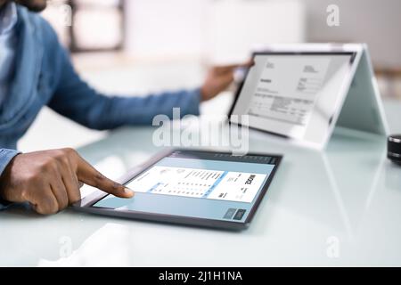 Young Businessman Using Laptop With Computer Screen Showing Invoice Stock Photo
