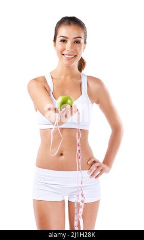 Diets, like clothes, should be tailored to you. Portrait of a healthy young woman holding an apple and a measuring tape. Stock Photo