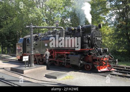 Steam locomotive refueling at the water crane in Drei Annen Hohne in Wernigerode, Saxony-Anhalt, Germany Stock Photo