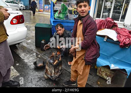 Kabul, Afghanistan. 22nd Feb, 2022. (2/22/2022) Kabul, Afghanistan, February March 2022. People warming themselves during copld day at a stove and open fire. (Photo by Teun Voeten/Sipa USA) Credit: Sipa USA/Alamy Live News Stock Photo