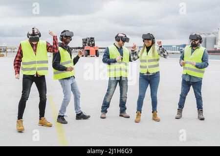Multiracial team of industrial workers using virtual reality headsets at shipping cargo port - Metaverse and freight logistic concept Stock Photo