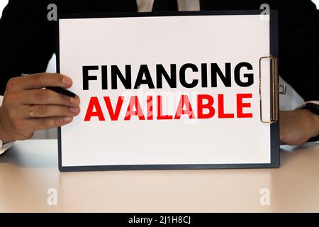 Financial Education, financial concept. Mason jar with coins inside, piggy bank and whiteboard on wooden table. Stock Photo