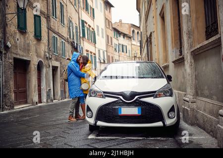 Happy couple enjoying the rain in the city together Stock Photo