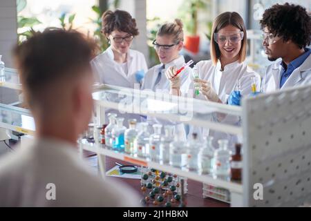 Lab technicians in lab looking liquid in test tubes Stock Photo