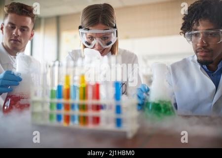 Young chemistry students in a laboratory relaxed atmosphere  doing an experiment with colorful chemicals. Science, chemistry, lab, people Stock Photo