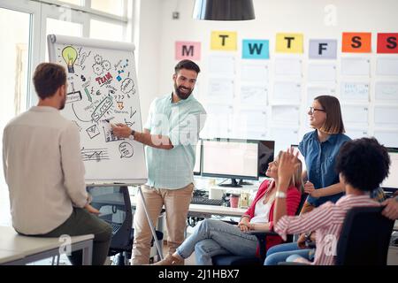 Group of multiethnic ambitious employees brainstorming together in the office Stock Photo