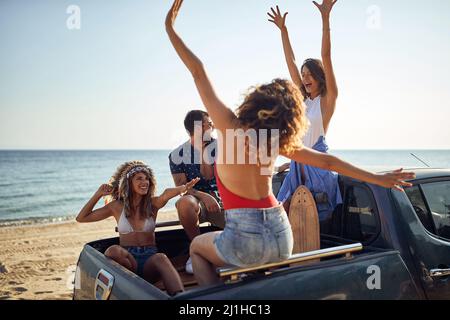 Group of college friends arriving to the beach while having roadtrip Stock Photo