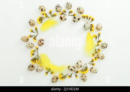 Frame of eggs and yellow flowers on white background. Flat lay, top view. Easter holiday Stock Photo