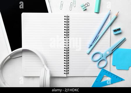 Blank notebook, gadgets and stationery on light grunge background Stock Photo