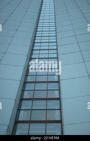 High-rise building on gray day. Architecture details. Surface of wall. Glazing in house. Stock Photo