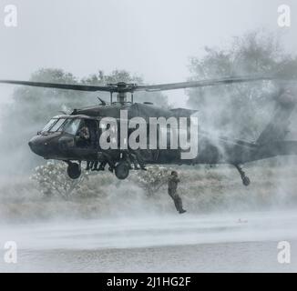 U.S. Army Soldiers, assigned to the  1st Special Forces Group (Airborne) and Royal Thai Army Special Forces Soldiers jump from a UH-60 Blackhawk helicopter as part of helo-cast training during Hanuman Guardian 2022 in Lopburi, Kingdom of Thailand, March 18, 2022. HG 22 provides a venue for both the United States and the RTA to advance interoperability and increase partner capacity in planning and executing complex and realistic multinational force and combined task force operations. (U.S. Army photo by Staff Sgt. Timothy Hamlin) Stock Photo