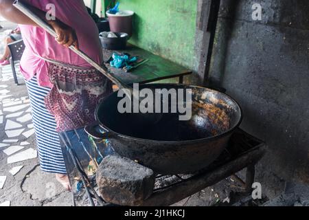 Elderly Nicaraguan woman cooking blood sausage in a large aluminum pot Stock Photo