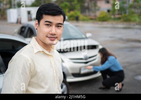 Happy businessman drivers do not worry after a car accident because have car accident insurance. And sad men drivers do not have car accident insuranc Stock Photo