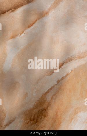 abstract golden yellow and brown color swirl design on cement wall texture background Stock Photo