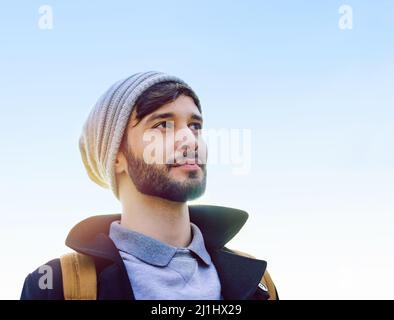 Where to after this. Shot of a thoughtful young man standing outdoors. Stock Photo