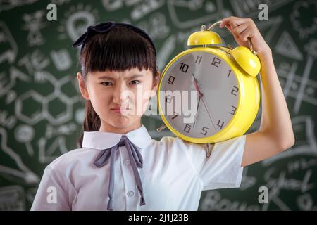 Primary school girl standing in front of the blackboard Stock Photo