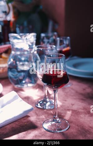 Table in restaurant with glass of aperitif in front Stock Photo