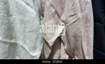 The texture of the fabric is made of natural linen. Crumpled material in light green and beige colors. Eco-friendly clothing for home and street Stock Photo