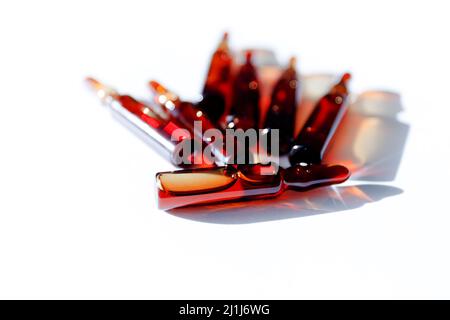 Medical brown glass ampoules with with medicine liquid close-up on the background of other ampoules. Stock Photo