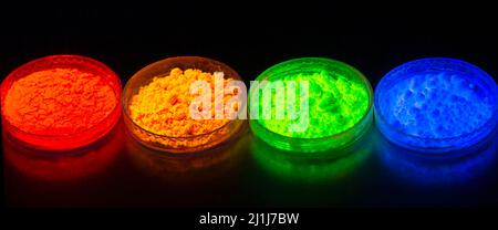 Fluorescent organic materials powder of red, yellow, green color for production OLED displays in UV light.Closeup. Stock Photo