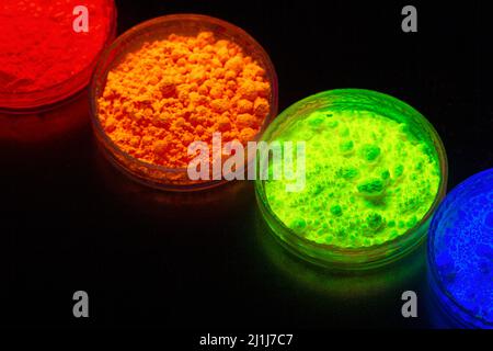 Fluorescent organic materials powder of red, yellow, green color for production OLED displays in UV light.Closeup. Stock Photo