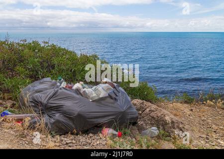 Spilled garbage on the beach of the big city. Empty used dirty plastic bottles. Dirty sea sandy shore the Black Sea. Environmental pollution. Ecologic Stock Photo