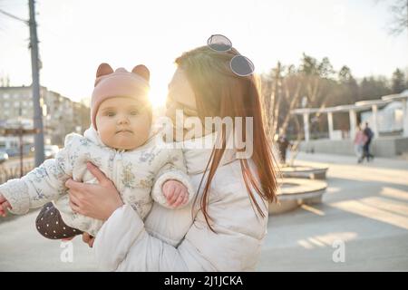happy harmonious family outdoors. mother throws baby up, laughing and playing in the summer Stock Photo