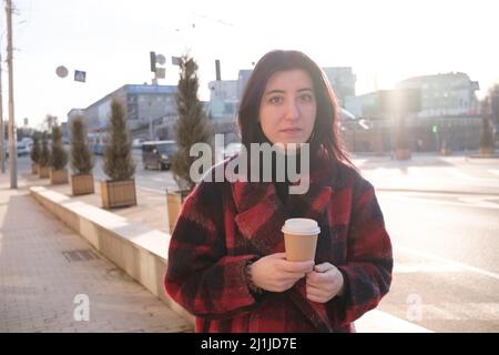 Woman drinking coffee in the sun, outdoor in sunlight light, enjoying her morning coffee.