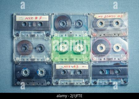 Old transparent cassette tapes arranged in a grid on blue sofa Stock Photo