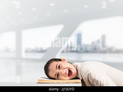 Bored business woman lying on desk Stock Photo