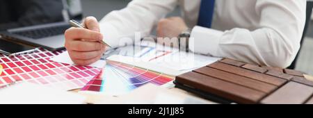A male designer chooses a color from a palette Stock Photo