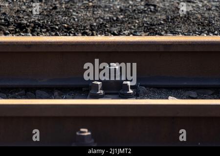 KPO clip rail fastening system and rusty steel railway at a narrow gauge train station in Germany Stock Photo