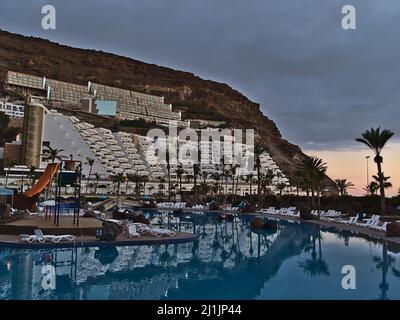 Beautiful view of Lago Taurito Water Park in the south of Gran Canaria, Spain in the evening with water slides and palm trees reflected in the pool. Stock Photo