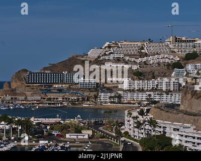 View of resort town Puerto Rico, southern Gran Canaria, Spain with large hotel buildings on the hills and beach on sunny day in winter season. Stock Photo