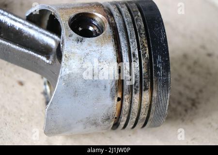 Piston from an old diesel engine with broken piston rings due to overheating, repair of mechanical moving parts Stock Photo