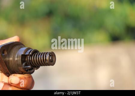 Close view of Spring and other parts of diesel fuel injector held in the hand Stock Photo